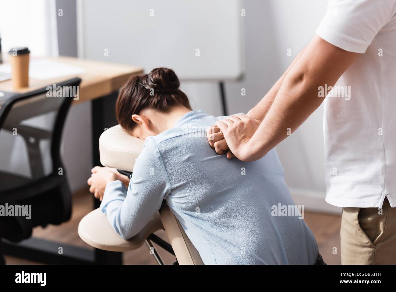 https://c8.alamy.com/comp/2DB531H/massage-therapist-massaging-brunette-woman-back-sitting-on-massage-chair-with-blurred-office-on-background-2DB531H.jpg