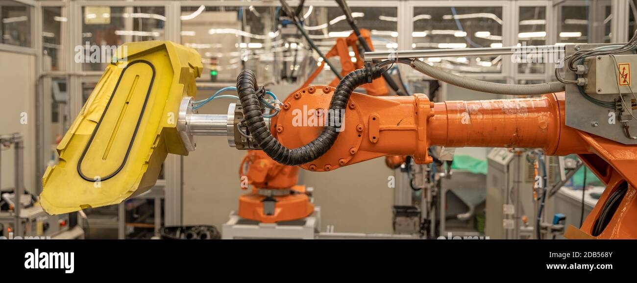 robot arms in the factory performs precise work according to the specified program. Stock Photo