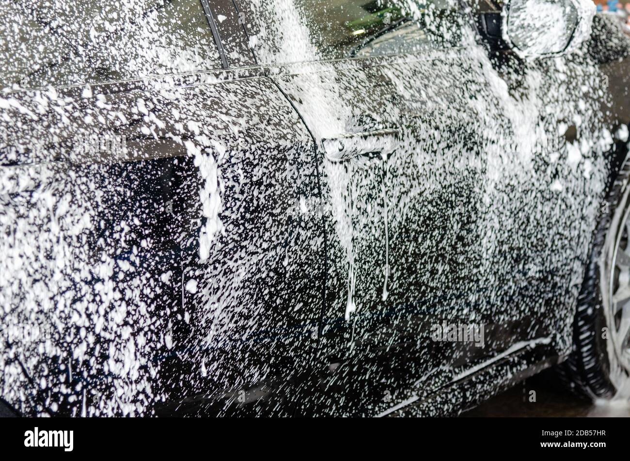 Cleaning black cars. Wash the car at the car wash station with foam