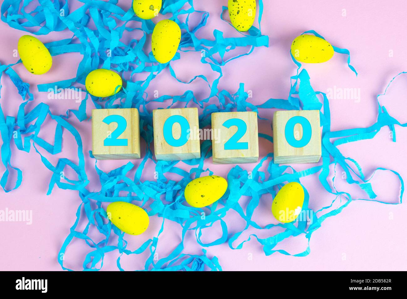 Word Easter on wooden cubes and surrounded with multiple egg decorations as a festive Easter background composition. Stock Photo