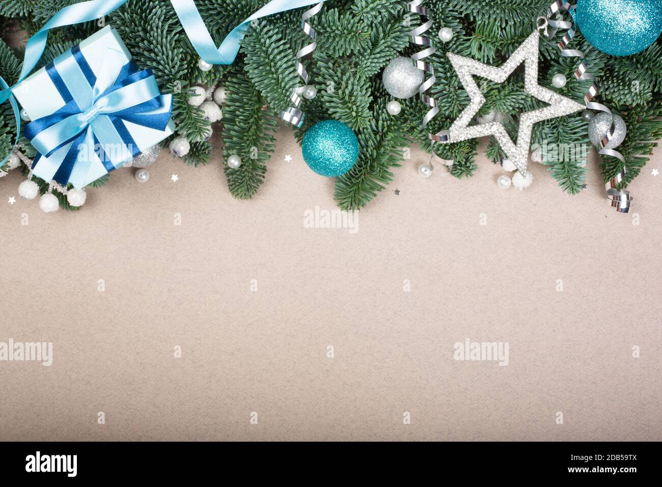 Christmas noble fir tree twigs gift and decorations on brown paper background with copy space for text Stock Photo