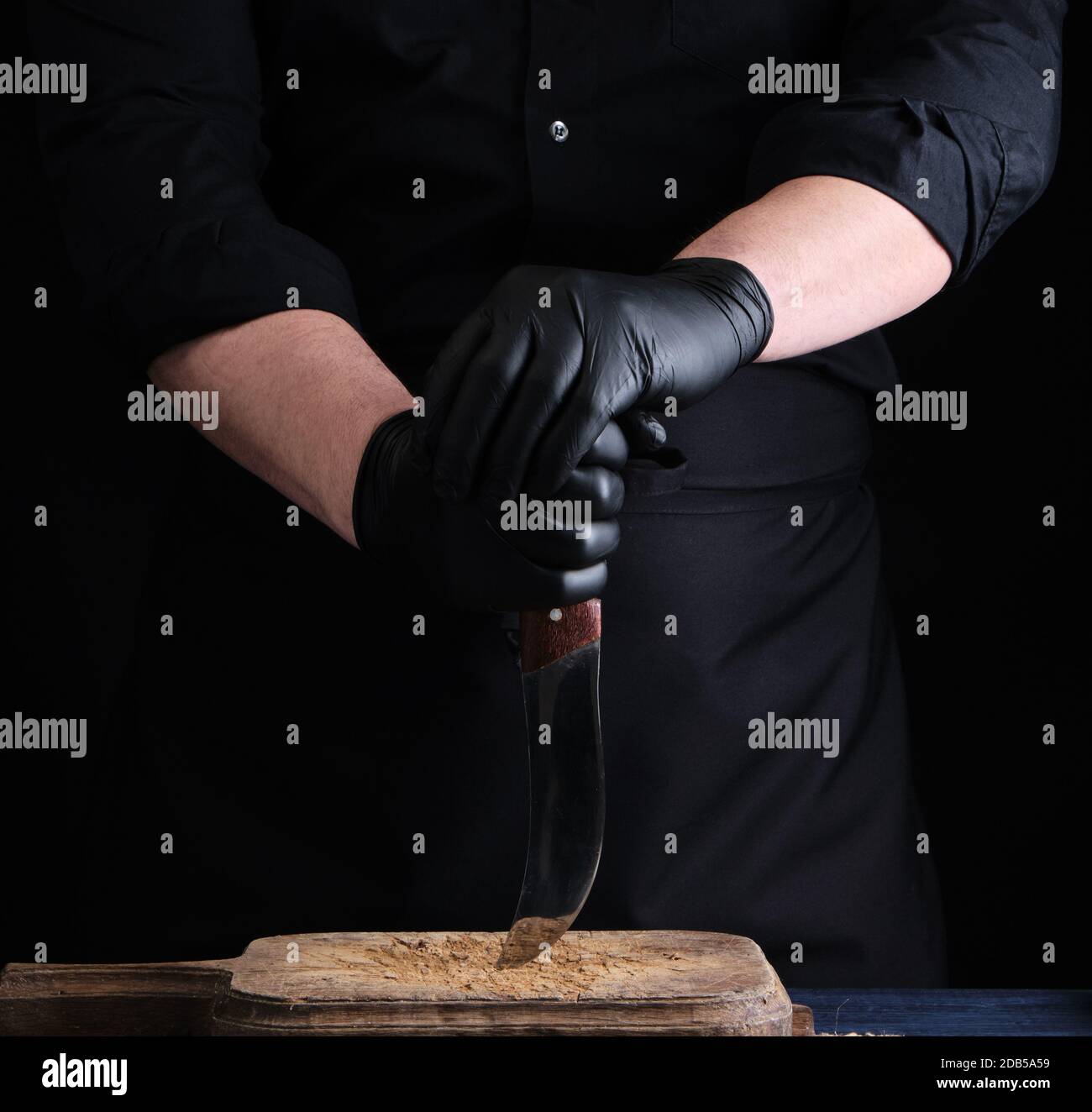 https://c8.alamy.com/comp/2DB5A59/chef-in-a-black-shirt-and-black-latex-gloves-holds-a-vintage-kitchen-knife-for-cutting-meat-low-key-2DB5A59.jpg