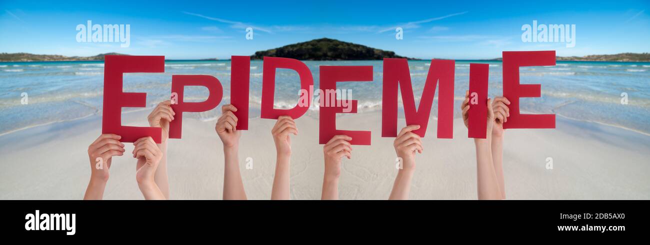 People Hands Holding Red German Word Epidemie Means Epidemic. Ocean And Beach As Background Stock Photo