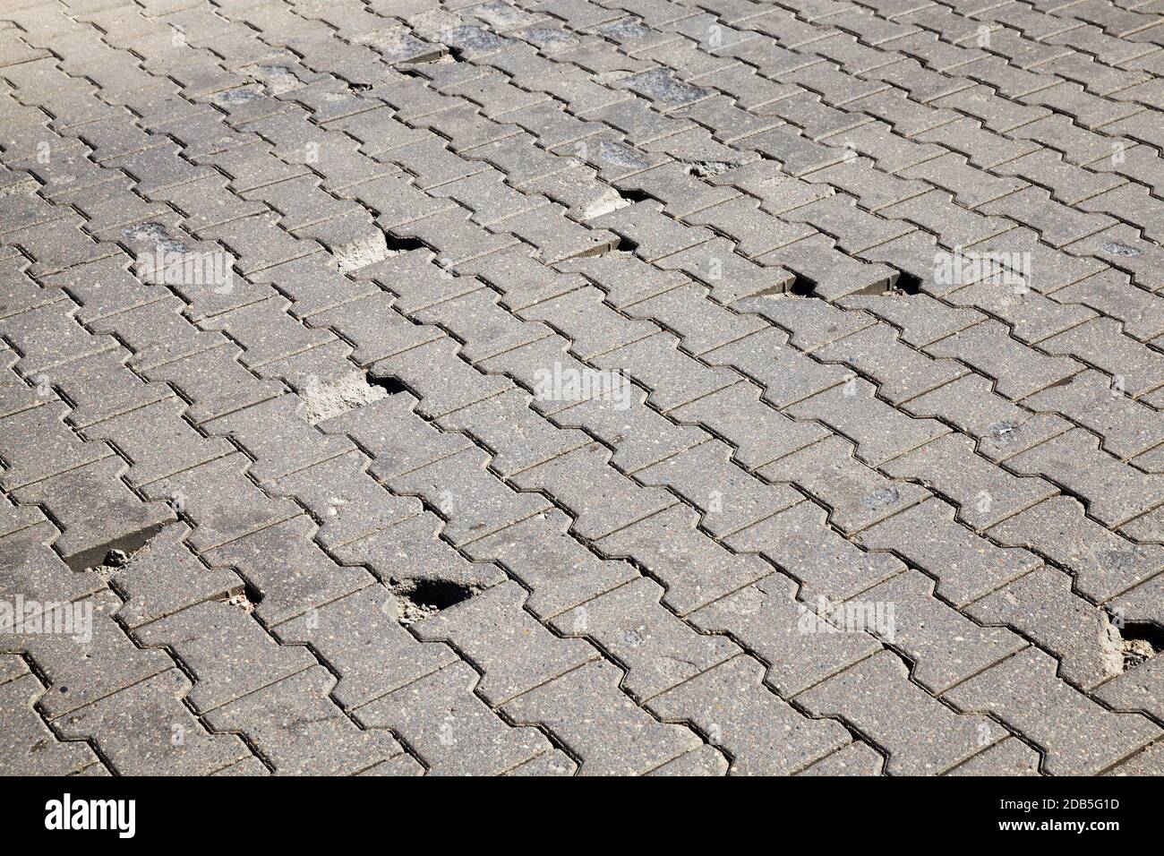 pedestrian road of tiles with lots of potholes and poor quality, details on the street and in the Park Stock Photo