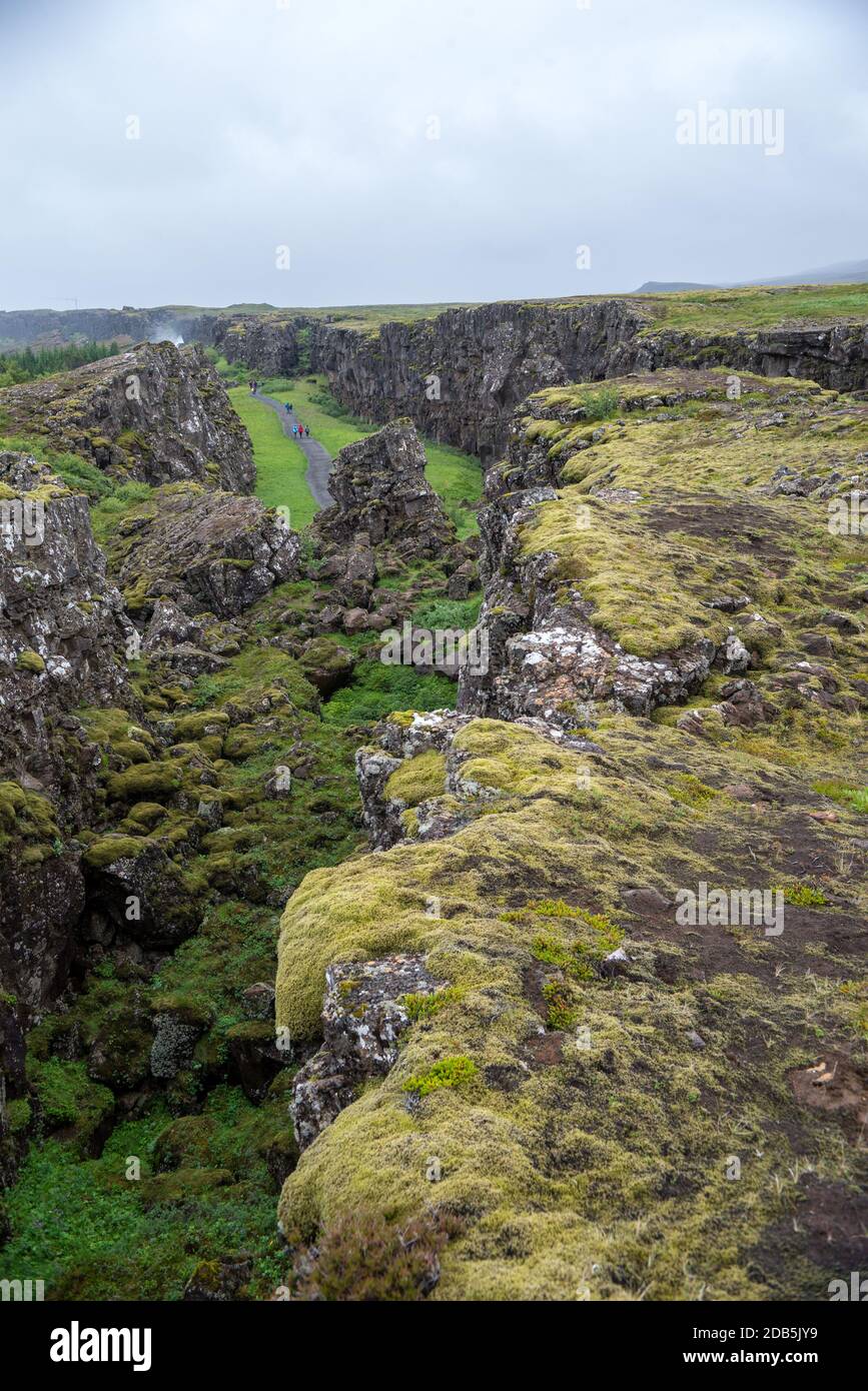 Thingvellir, Iceland - July 19, 2017: Tourists walk through the Almannagja fault line in the mid-atlantic ridge north american plate in Thingvellir Na Stock Photo