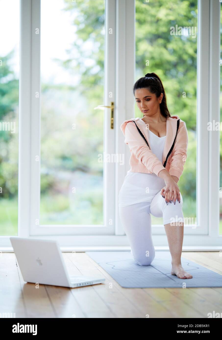 Woman working out to online workout program Stock Photo