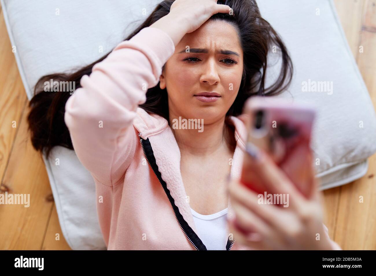 woman looking shocked looking at message Stock Photo