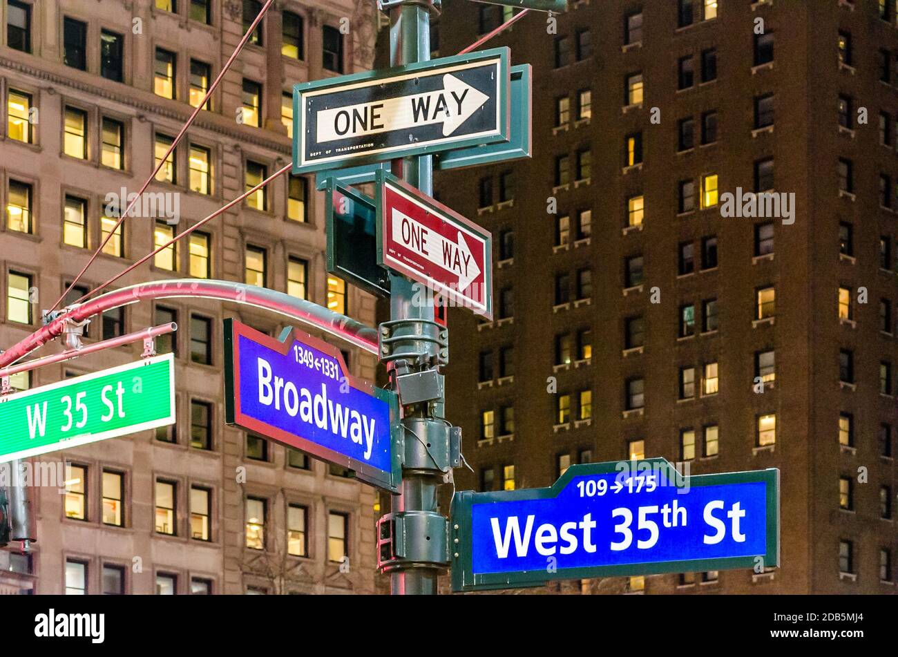 New York City Manhattan Street Signs at Night. Broadway and West 35th St. Buildings in Background. Manhattan, New York City, USA Stock Photo