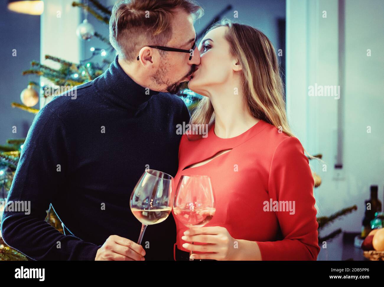 Middle aged couple in romantic pose in front of Christmas tree Stock Photo