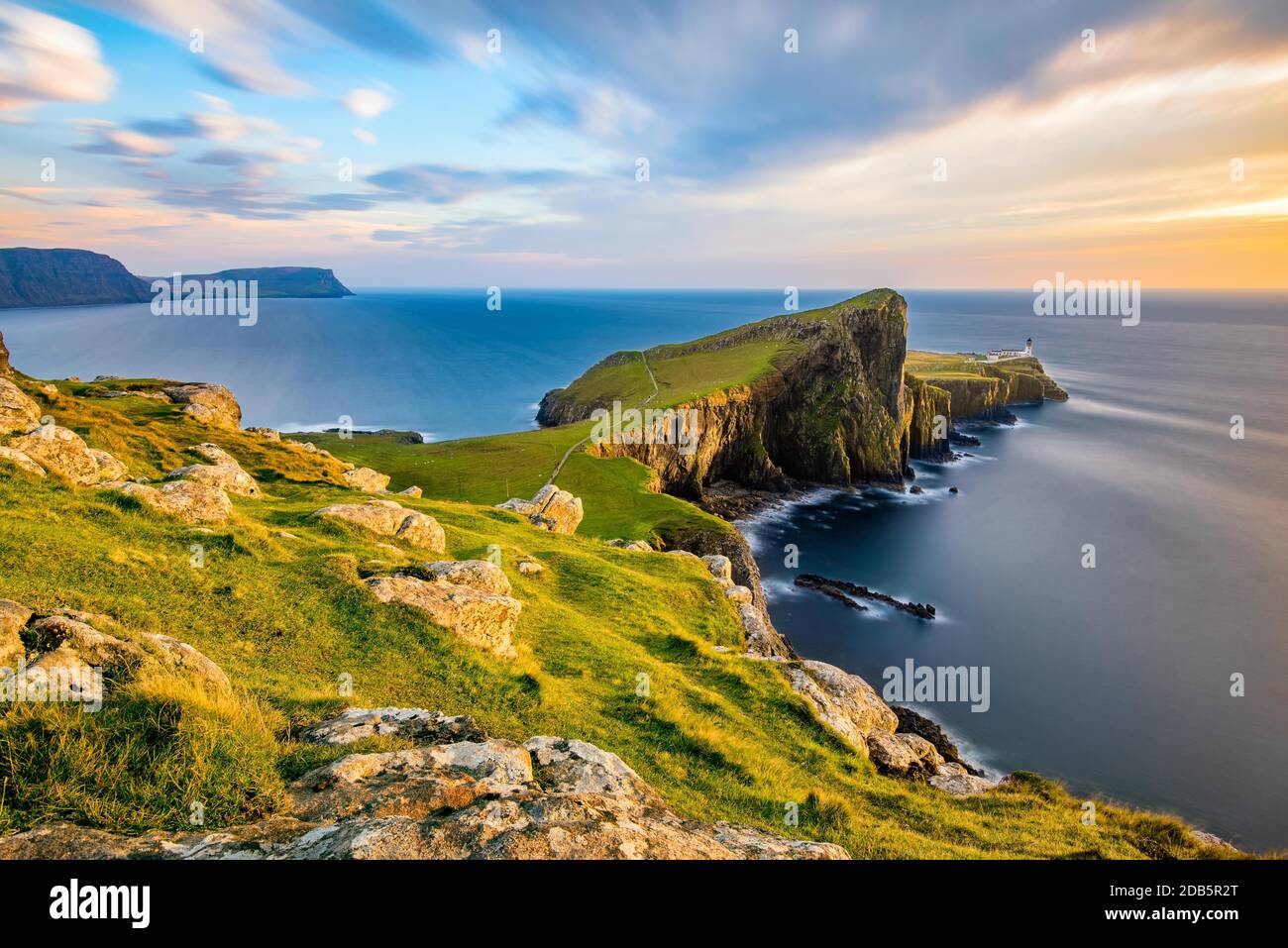 Neist Point Lighthouse on the Isle of Skye bathed in golden light from the setting sun. Stock Photo