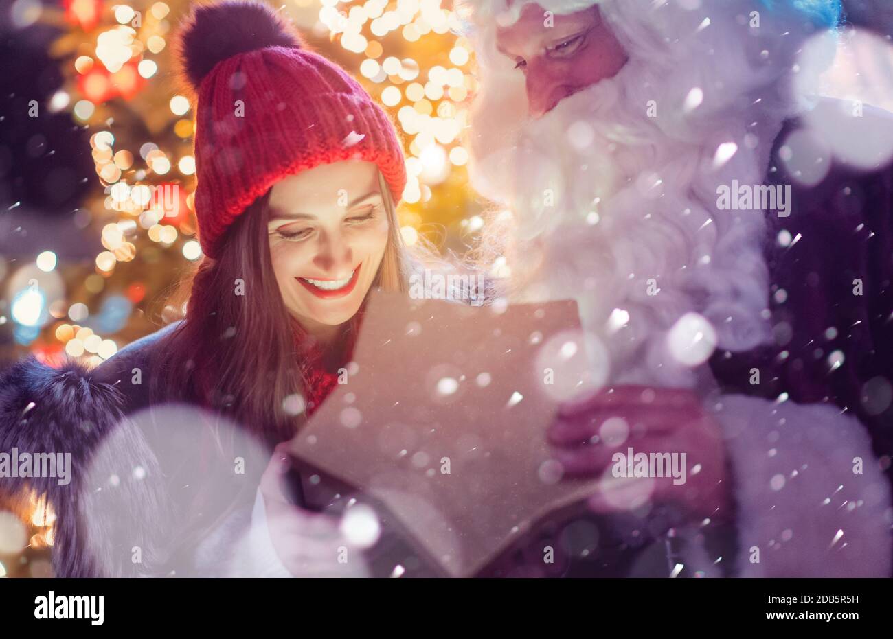 Santa Claus presenting beautiful girl with a present Stock Photo - Alamy