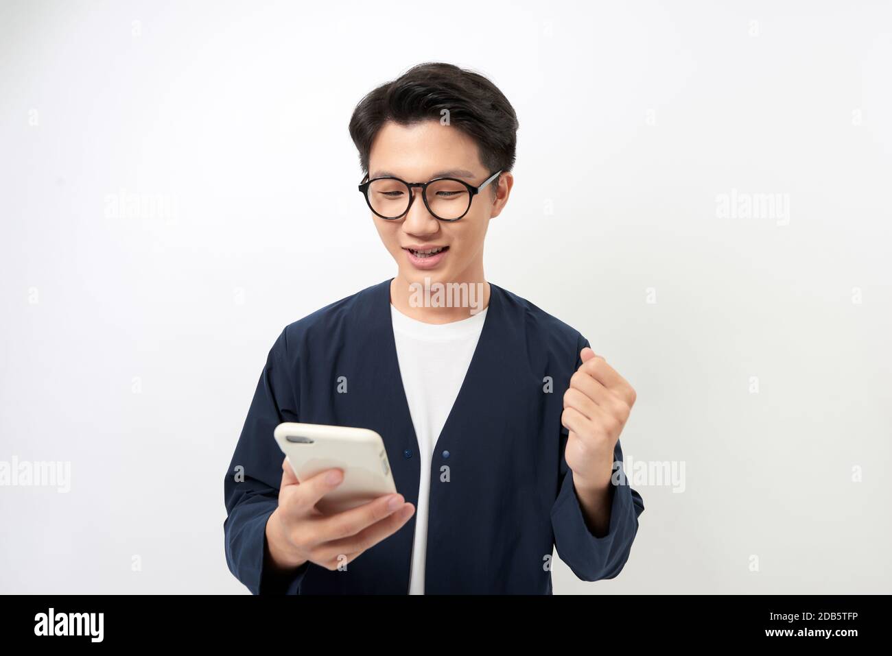 Surprised young man is holding phone and reading message isolated over ...