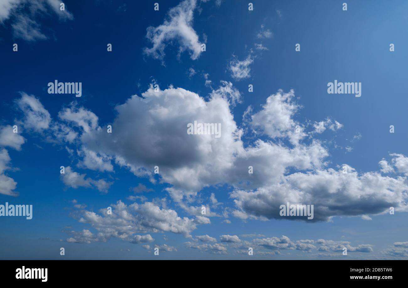 Blue sky with clouds in sunlight background Stock Photo - Alamy