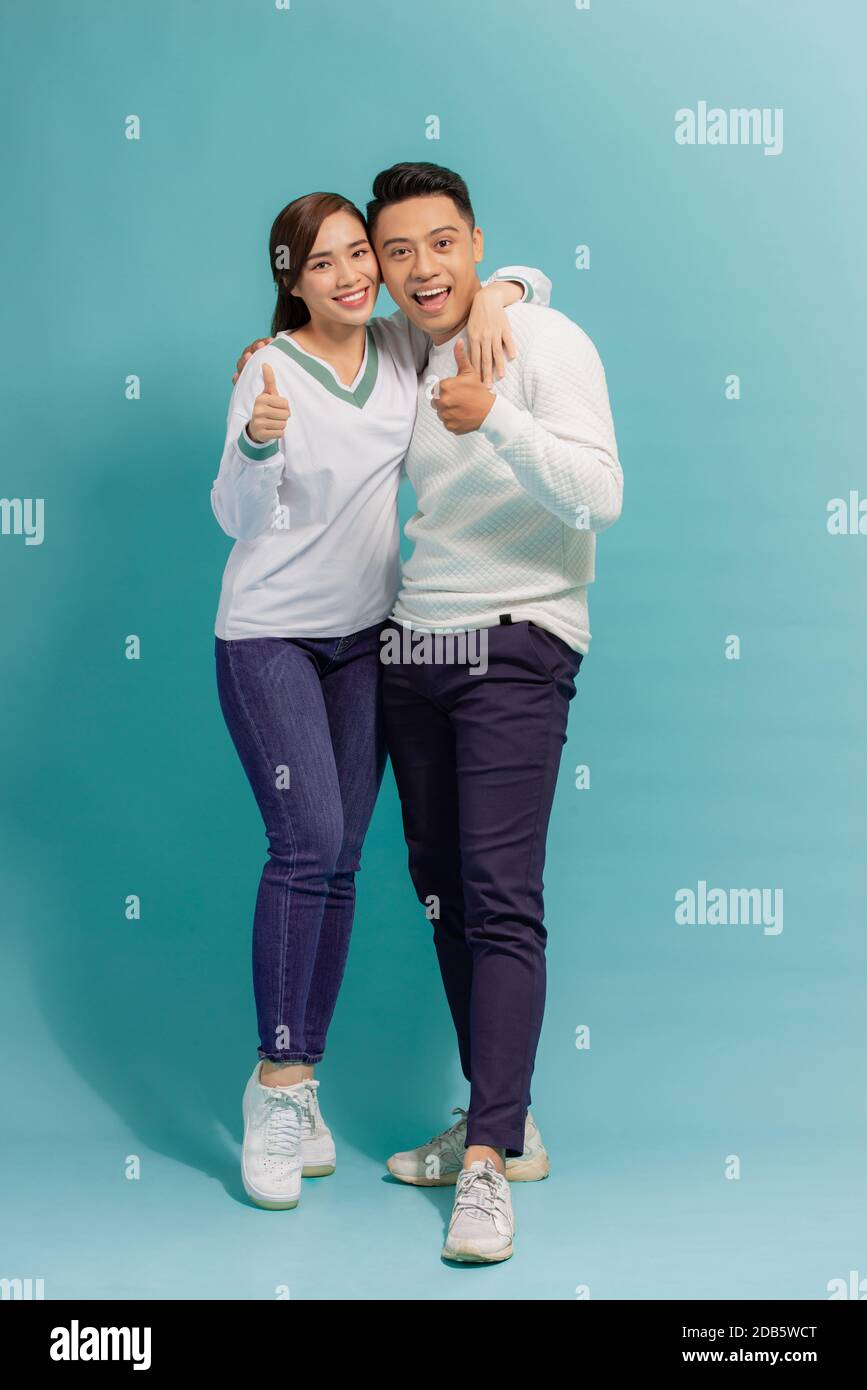 portrait of happy young stylish couple in love having fun in studio isolated on blue background Stock Photo