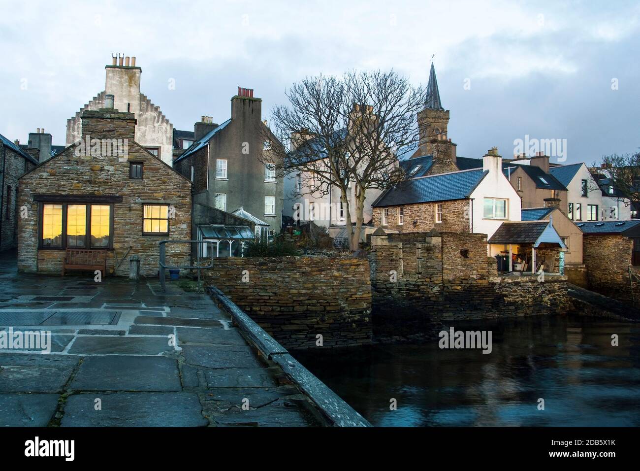 Close waterfront view of traditional vintage houses and tree in scottish town Stromness Stock Photo