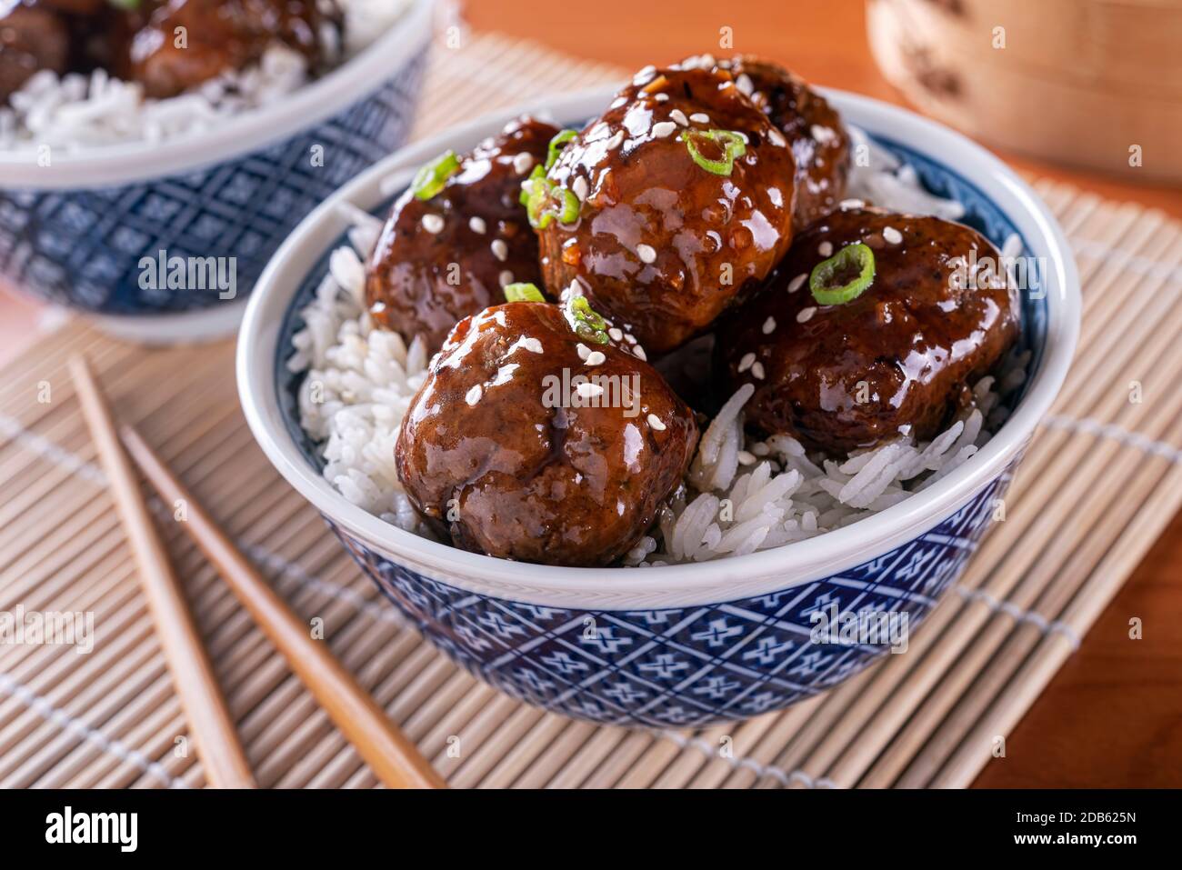 A bowl of delicious honey garlic meatballs with steamed rice. Stock Photo