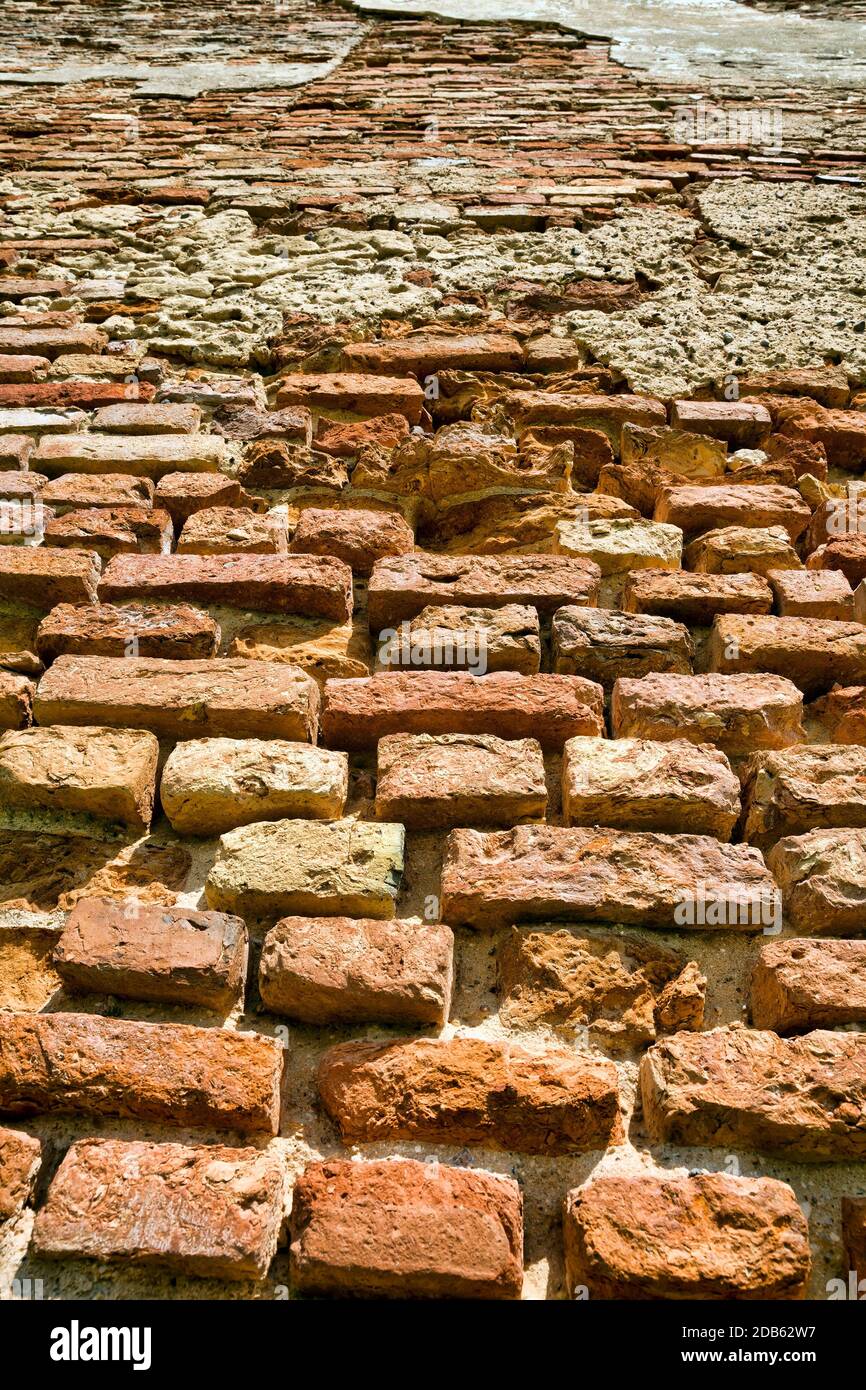 the old brick wall of a building made of red brick, part of the wall is being destroyed, closeup Stock Photo