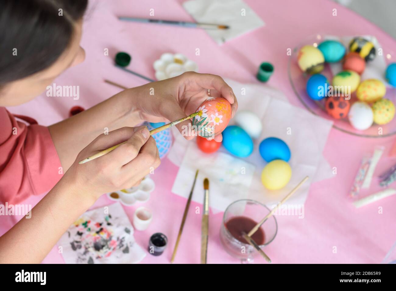 Girl paints chicken eggs for Easter Stock Photo