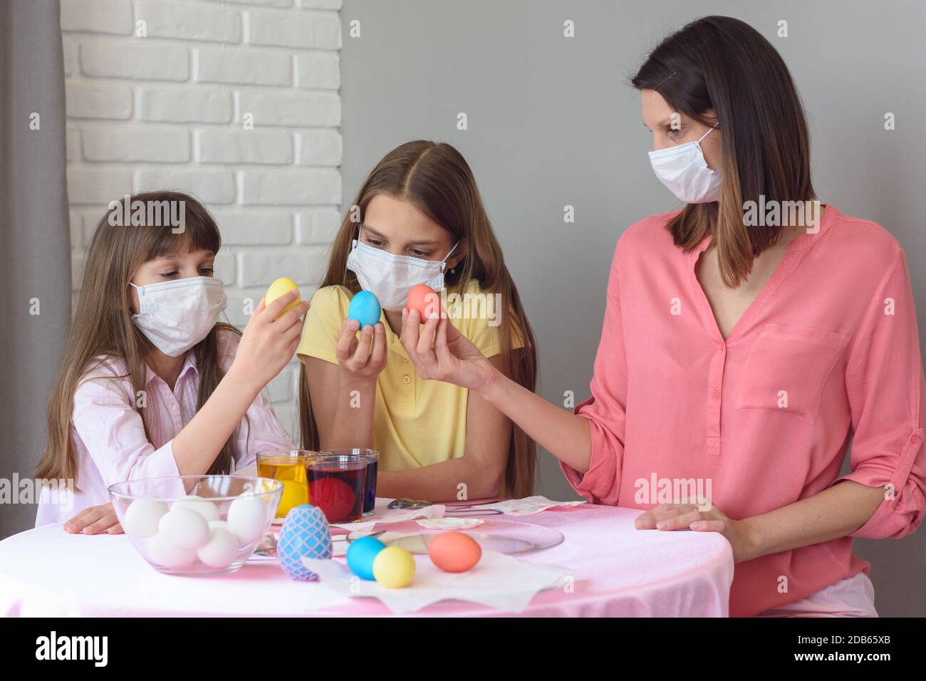 Mom and two quarantined daughters painted eggs for Easter Stock Photo