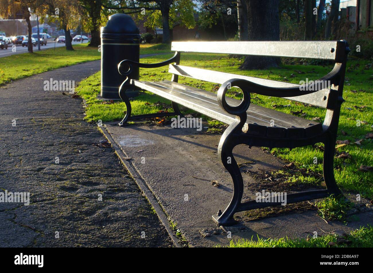 Empty sunlit bench seat in a public park Stock Photo