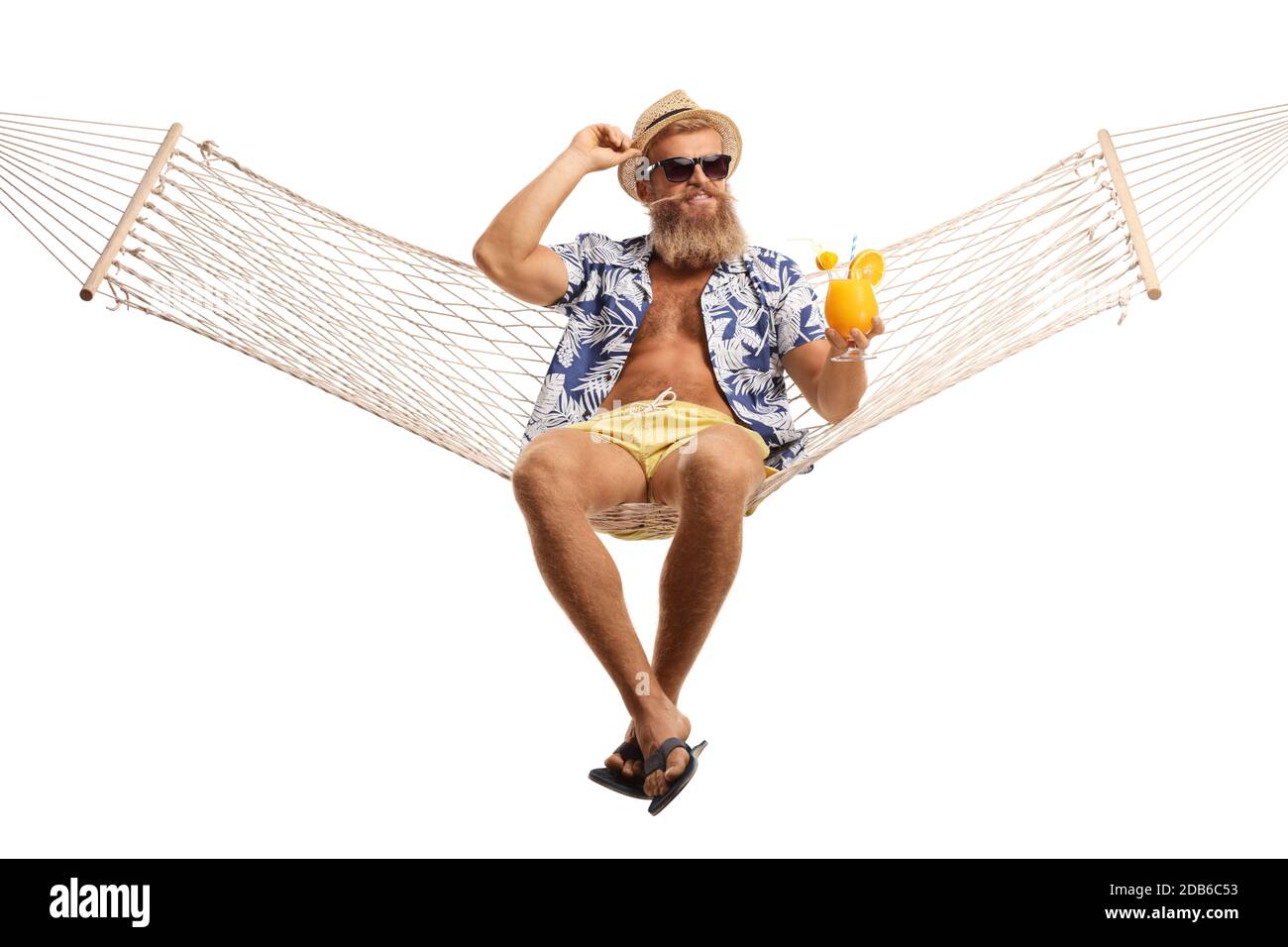 Bearded tourist with hat and sunglasses enjoying a cocktail on a hammock swing isolated on white background Stock Photo