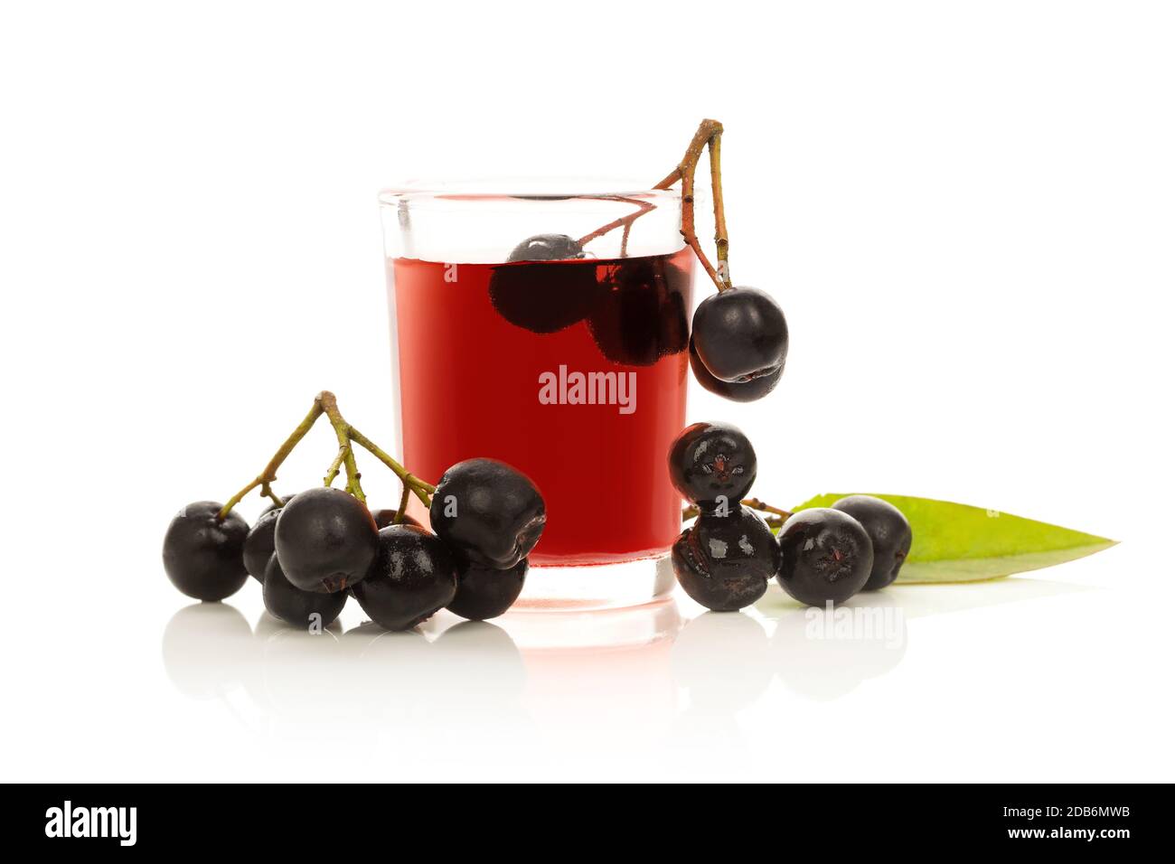 Fresh juice of ripe black chokeberry in glass and berries. Aronia berry drink. Stock Photo