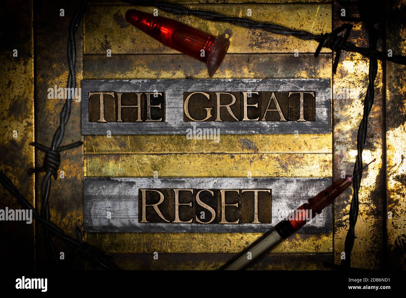 The Great Reset text message on textured grunge copper and vintage gold background with barbed wire and syringe and laboratory vial Stock Photo