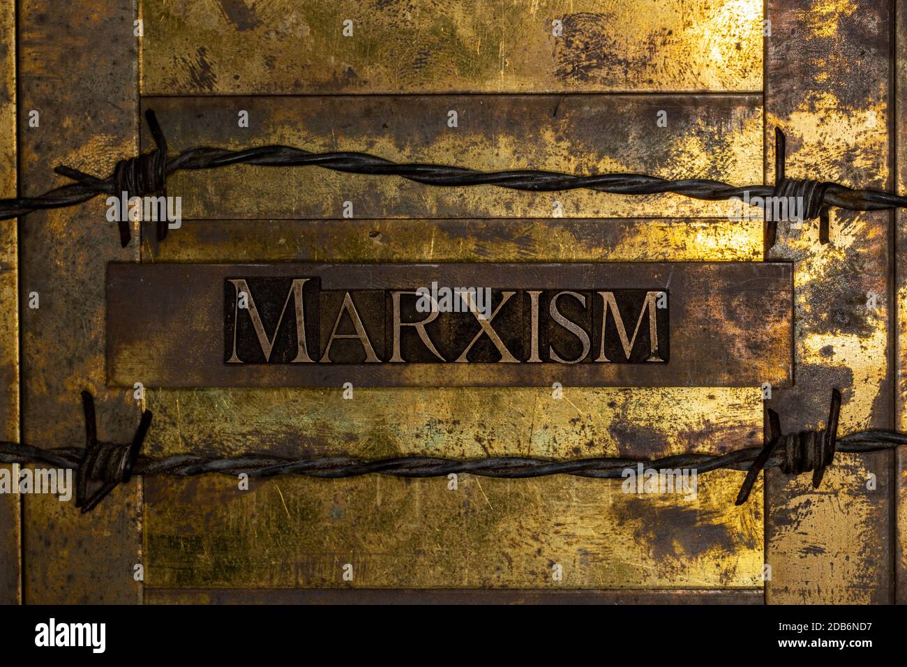 Marxism text on vintage textured grunge copper and gold background lined with barbed wire Stock Photo