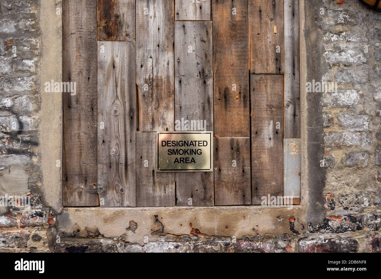 Designated Smoking Area sign mounted on a boarded up window Stock Photo