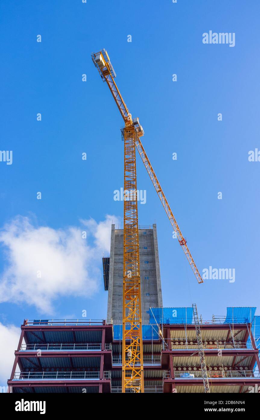 City Quays 3 construction continues, showing a yellow crane against a blue sky, Belfast, Northern Ireland Stock Photo
