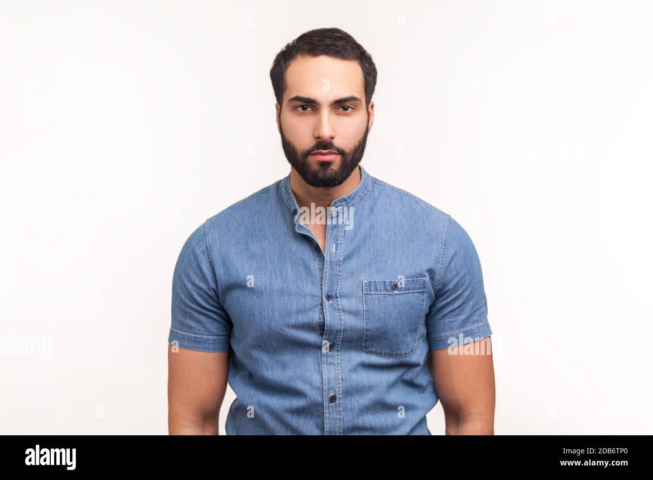 Portrait of attentive self confident bearded man looking at camera with serious expression, unsmiling determined business man. Indoor studio shot isol Stock Photo