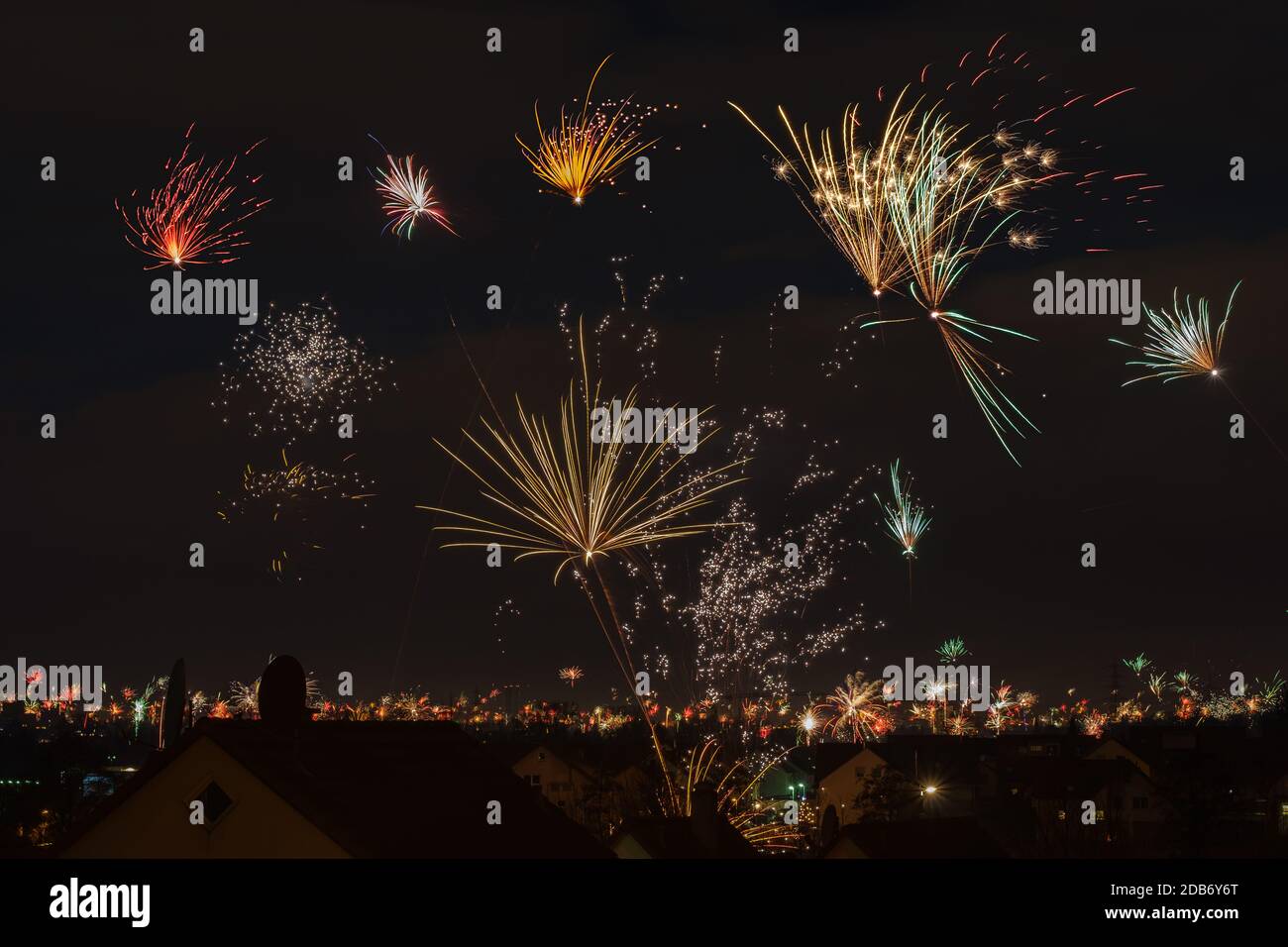 Coloured firework in dark sky at new year over a village Stock Photo