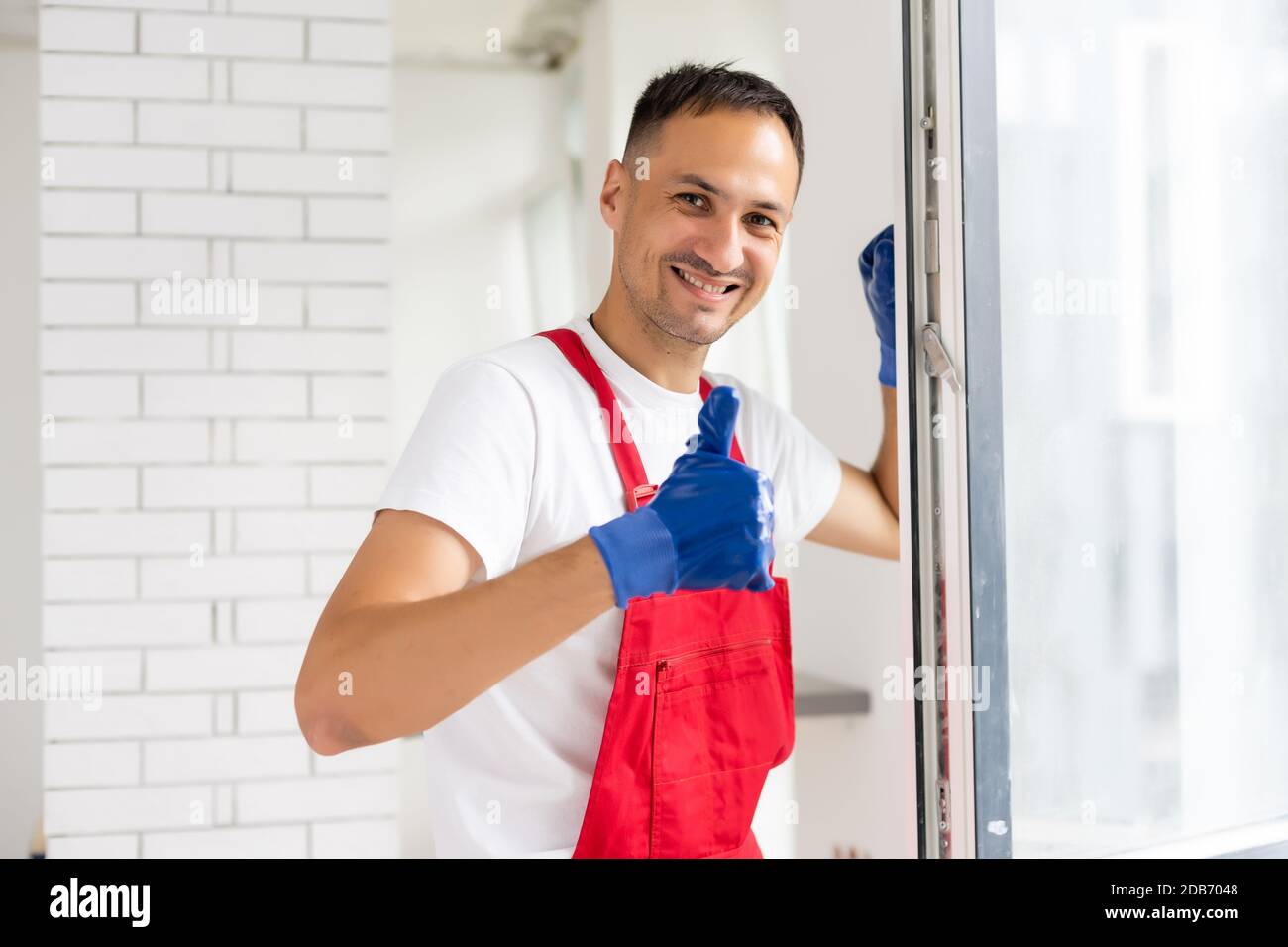 master with a screwdriver sets fittings on the window Stock Photo