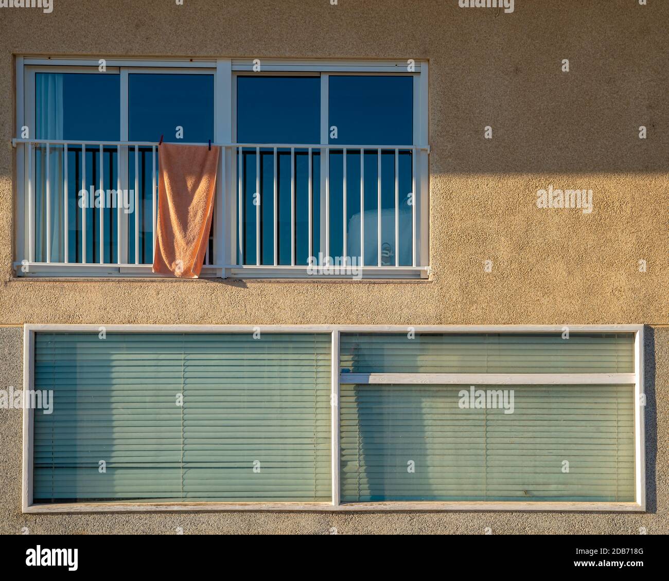 Detail of windows of dwelling house with towel on balcony Stock Photo