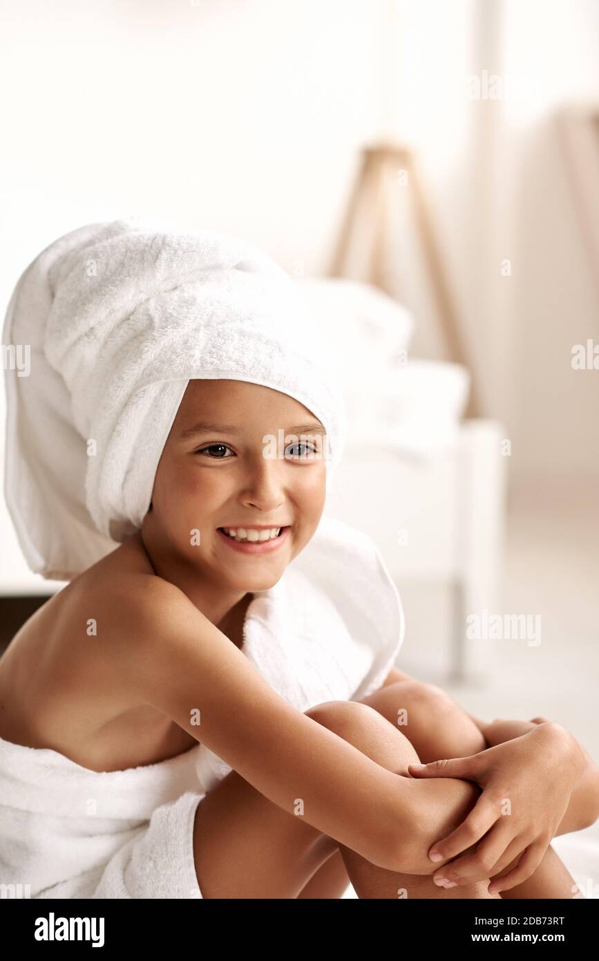 Cute girl wearing a bathrobe with wet hair after bath or shower