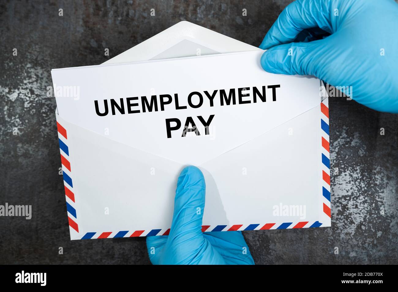 Elevated View Of A Person Removing Paper From Envelope Over Office Desk