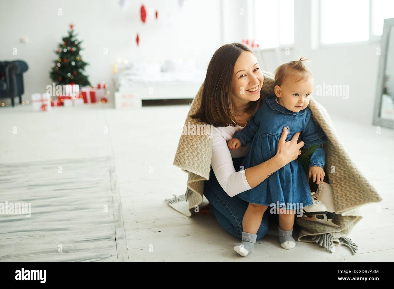 Portrait of a happy mother and her daughter having fun sitting on the floor at home. Stock Photo