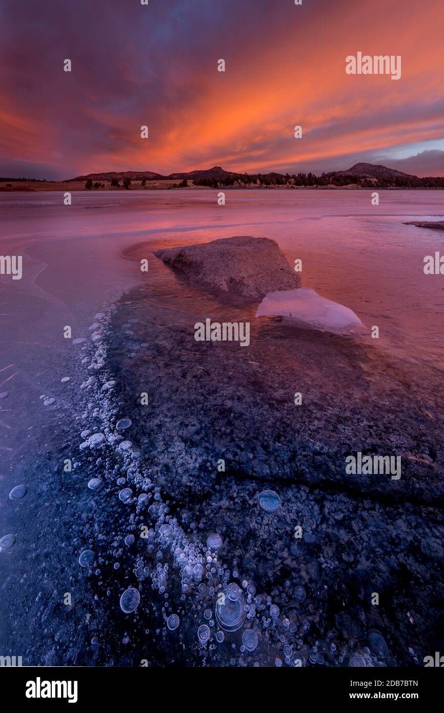 Colorful frozen Lake Dewiest with ice bubbles during sunset in Westcliffe, Colorado. Stock Photo