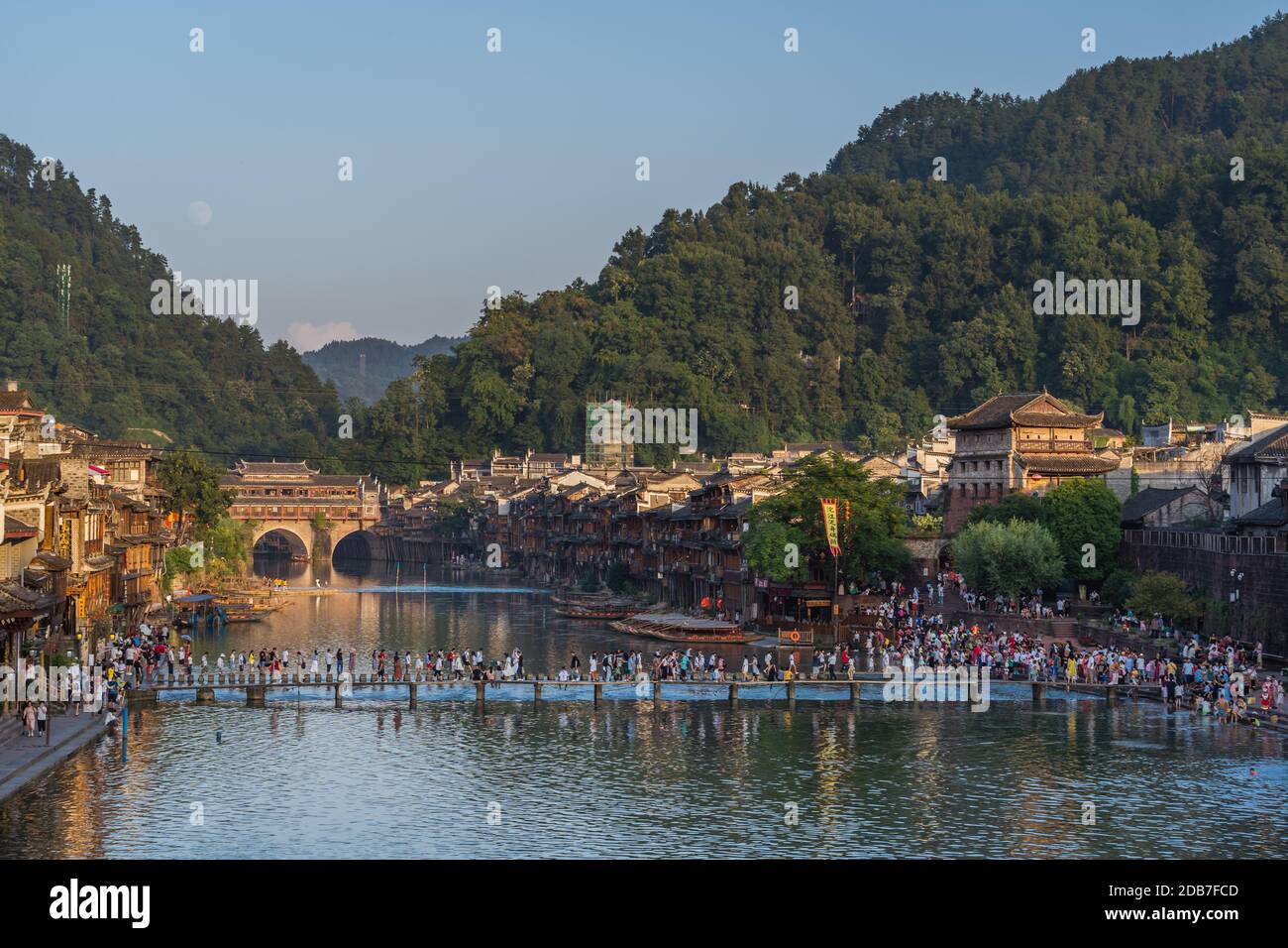 Feng Huang, China -  August 2019 : People crossing Tuo Jiang Tuojiang river, flowing through the centre of Fenghuang Old Town, Hunan Province Stock Photo