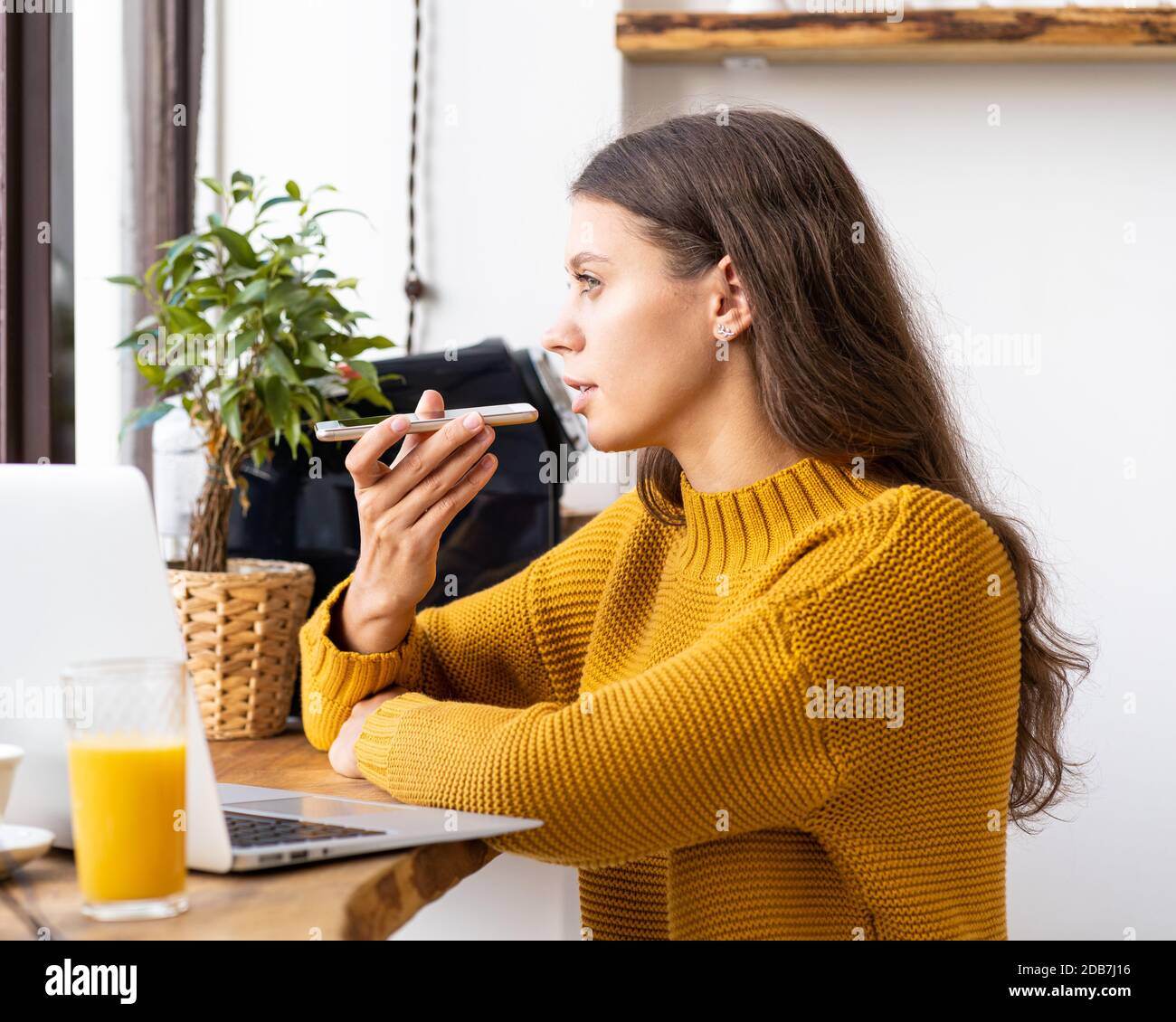 Portrait of positive young woman recording audio message, speaking to microphone Stock Photo
