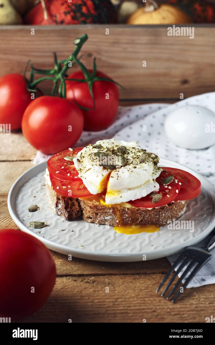 Open sandwich, toast with tomatoes and poached egg. Stock Photo