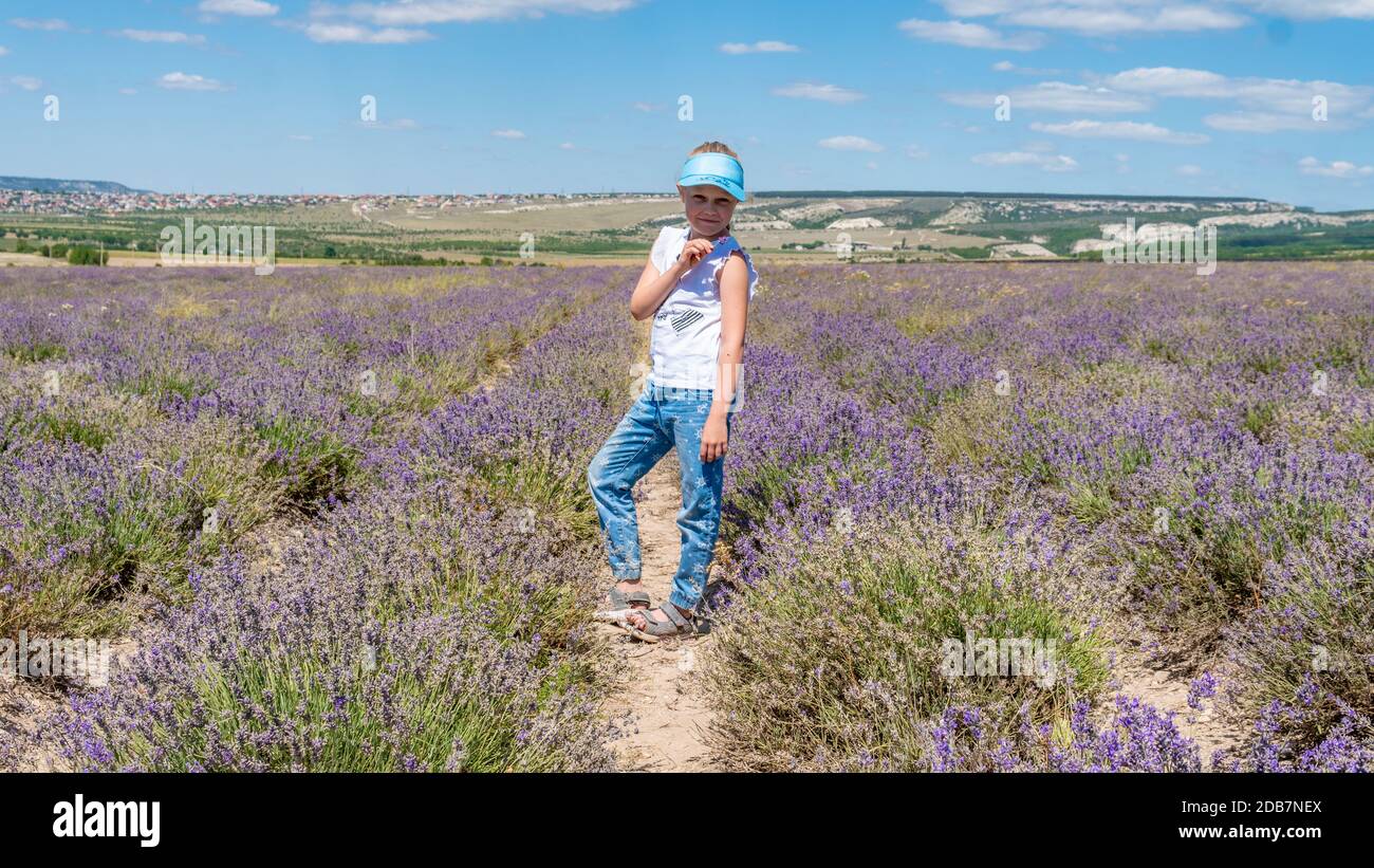 Smiling lady in a lavender field with a lovely smile in sunglasses with white skin stands Stock Photo