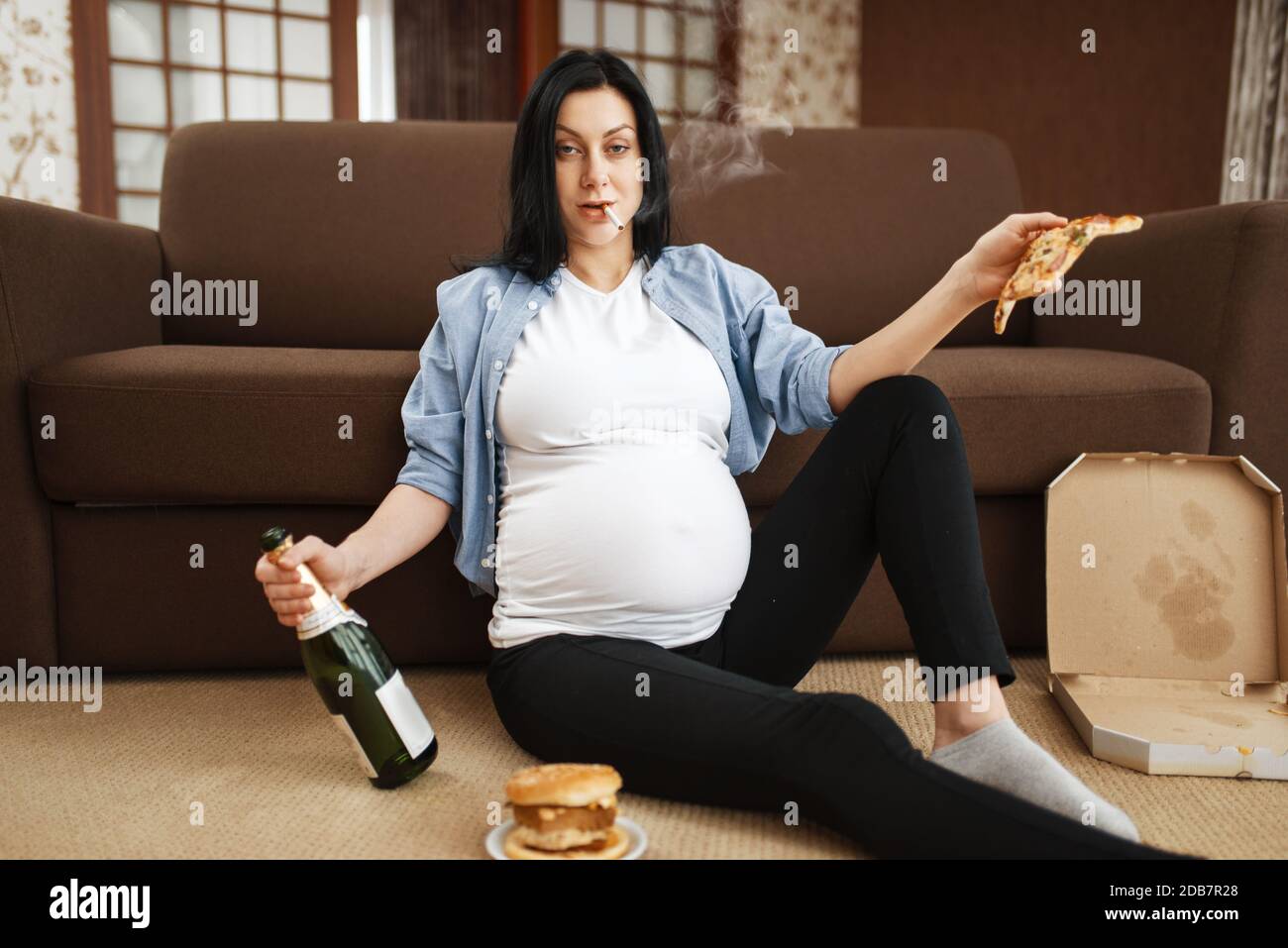 Pregnant woman with belly smoking and drinks alcohol at home. Pregnancy