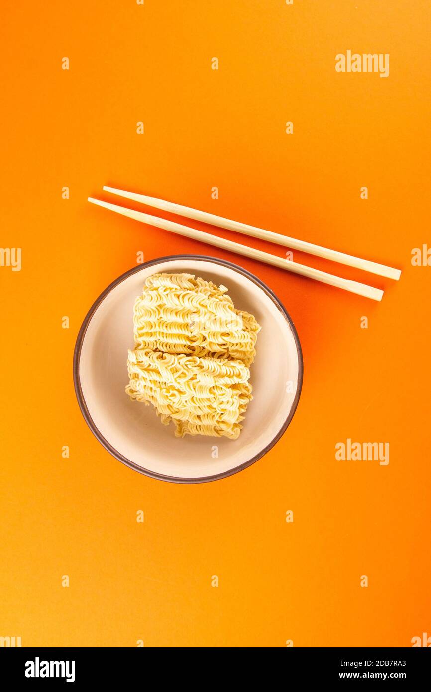 Instant noodles with wood sticks. Asian fast food on a orange