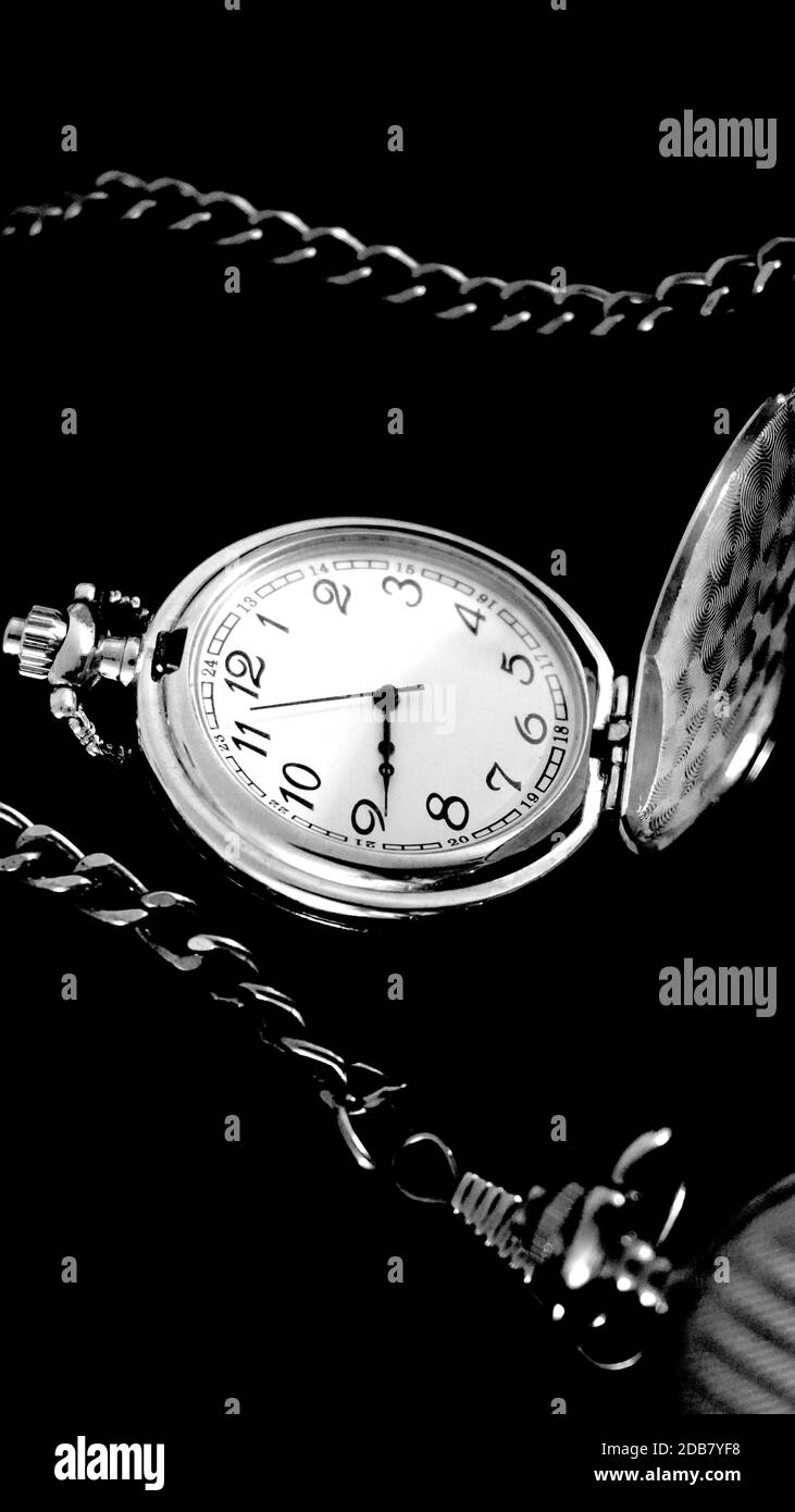 Old antique pocket watch with chain on black material. Time concept