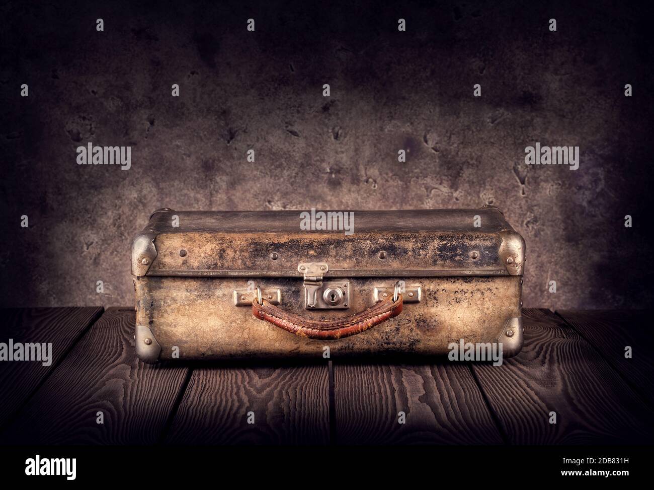 Old shabby suitcase on dark background Stock Photo