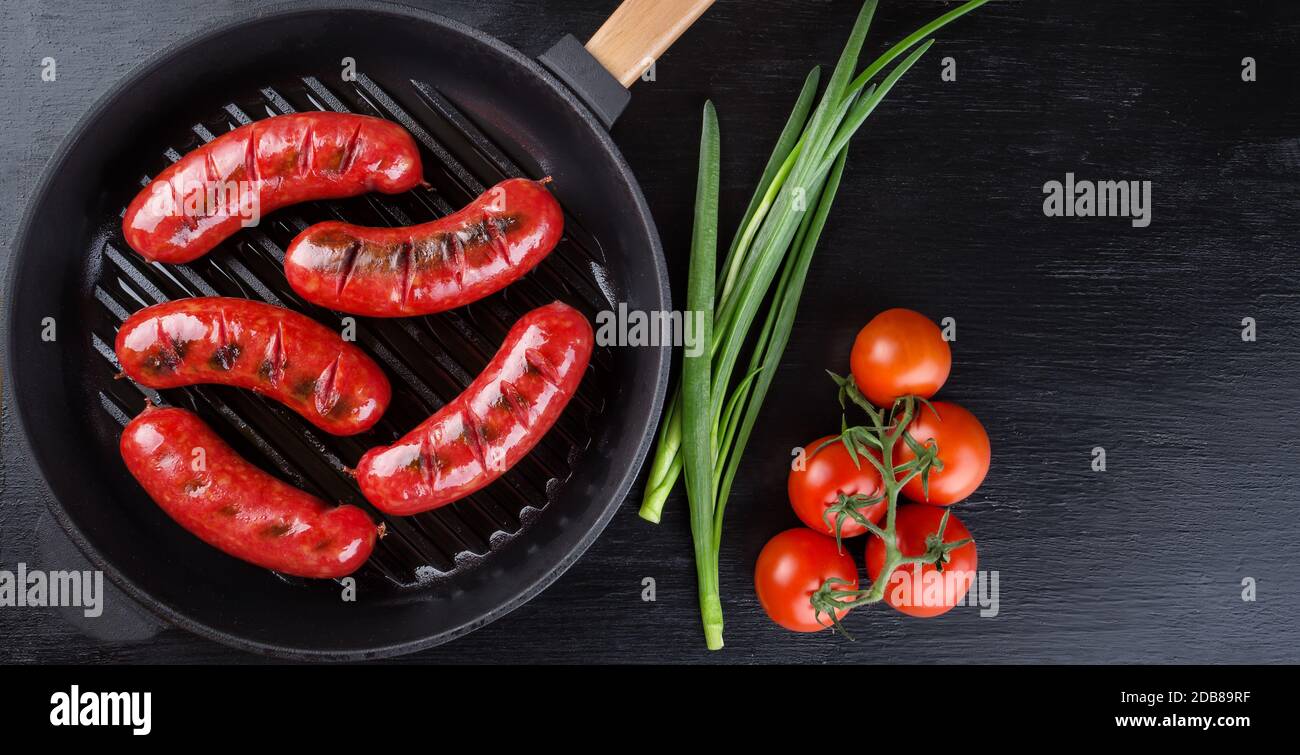 https://c8.alamy.com/comp/2DB89RF/frying-pan-with-fried-sausages-and-tomatoes-with-onions-side-by-side-black-background-view-from-above-copy-space-2DB89RF.jpg