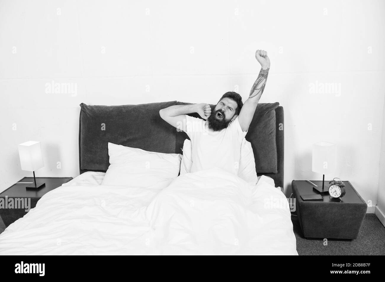 Sleepy early morning. Bearded with sleepy look in morning. Sleepy hipster stretch and yawn in bed. Wokeup sleepy. Awakening. Bedtime routine. Nap time. Feeling as though he got no sleep at all. Stock Photo