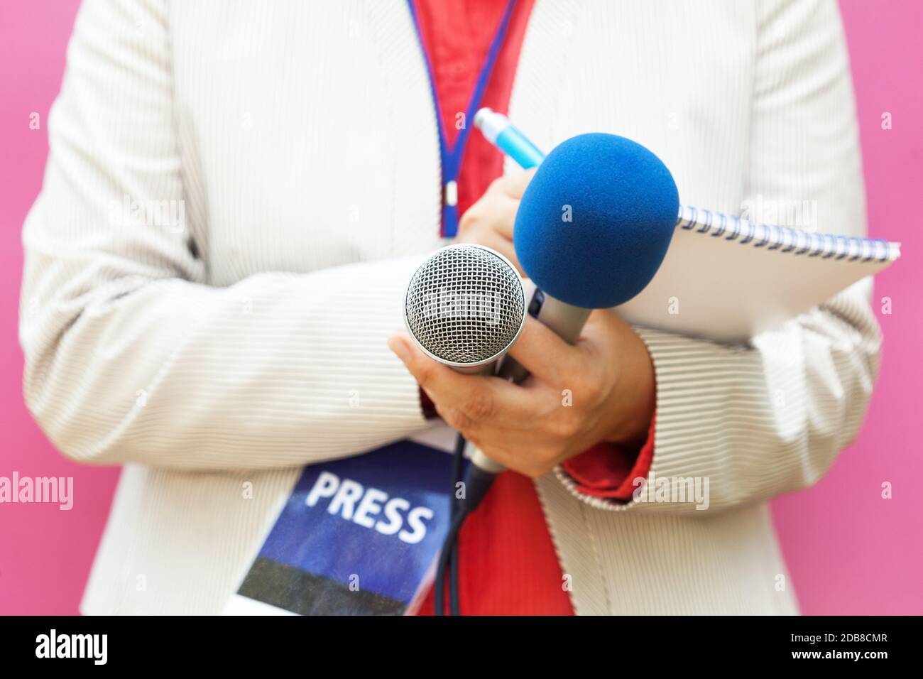 Female reporter at press conference, writing notes, holding microphone ...