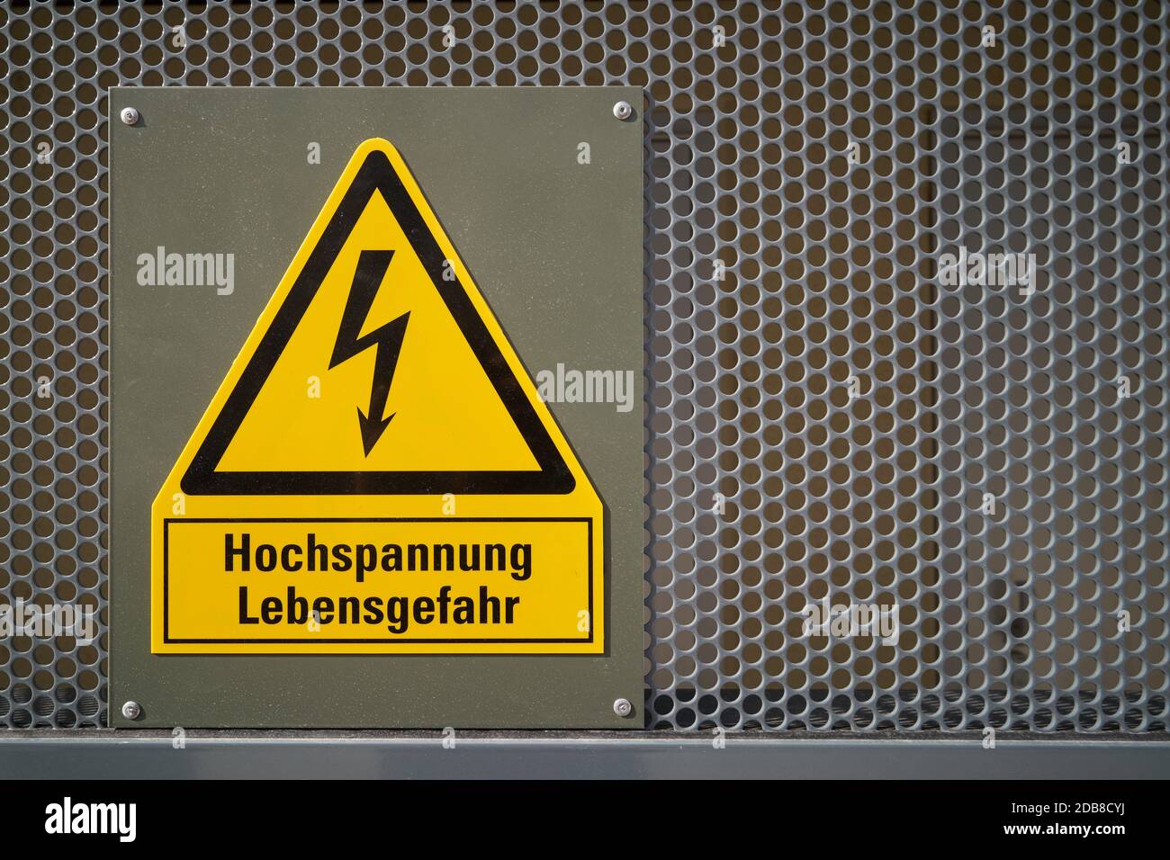 yellow sign with the inscription high voltage Danger to life Stock Photo